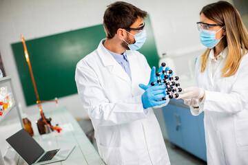 Young chemists holds molecular model in the lab