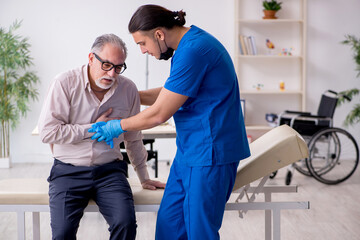 Fototapeta premium Old patient visiting young male doctor