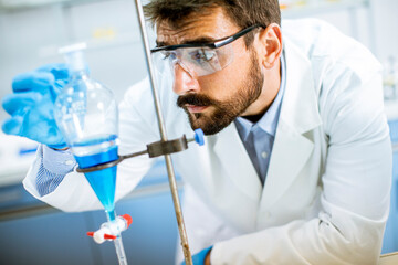 Researcher working with blue liquid at separatory funnel