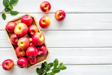 Top view of red apples with green leaves on kitchen table
