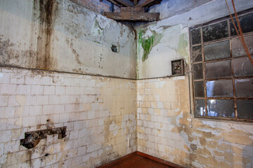 Cozinha abandonada em ruínas, com paredes sujas úmidas com tinta descascando em casa antiga