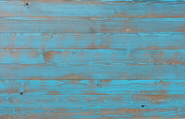 A wall made of light blue varnished spruce wood in vintage style where the wood structure shines through