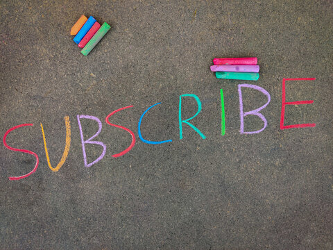 The inscription text on the grey board, SUBSCRIBE. Using color chalk pieces.
