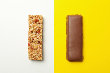 Tasty granola bars on two tone background, top view