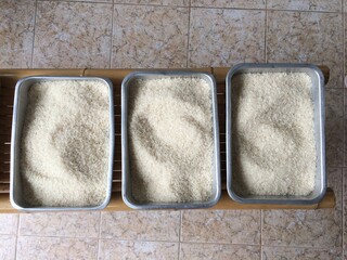 Raw rice, white jasmine rice, stacked together in a tray.