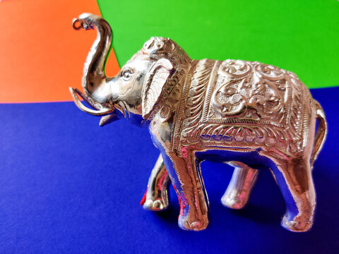 Silver color standing elephant toy isolated on blue background.Selective focus - Powered by Adobe