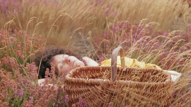 Une jeune femme fait une sieste dans un champ fleurie, ambiance automnale.