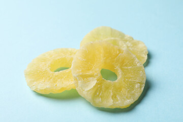 Tasty dried pineapple slices on blue background