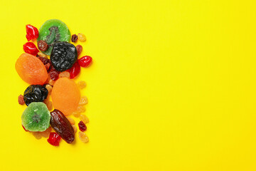 Tasty dried fruits on yellow background, space for text