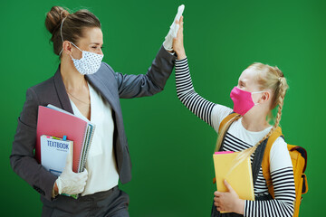 female teacher and pupil high five isolated on chalkboard green - Powered by Adobe