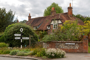 a typical English country home in Hambledon in Hampshire with direction signs pointing to...