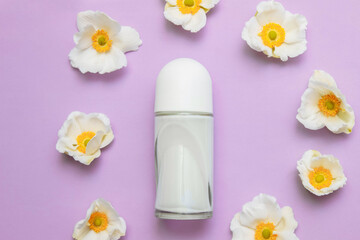 Roller deodorant bottle with white Orchid flowers on a pink background top view, personal hygiene concept, sweat protection, cosmetics and dermatology, fresh fragrance.