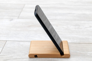 Black smartphone on a wooden stand. Accessory for gadgets