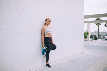 Female athlete leaned with one leg on wall