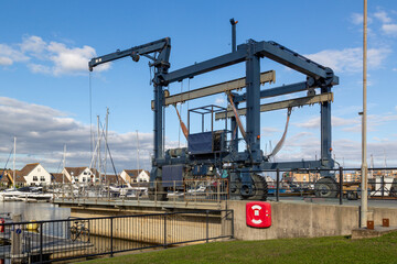 Fototapeta na wymiar a boat crane lift on a marina use for lifting boats out of the water for repairs
