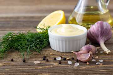 Fototapeta premium Mayonnaise sauce with garlic, egg, oil and herbs on wooden background