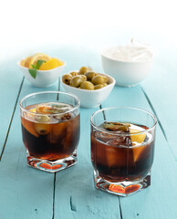 black vermouth with olives on blue wooden background