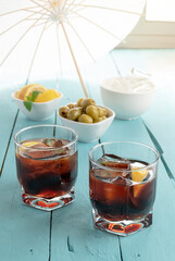 black vermouth with olives on blue wooden background