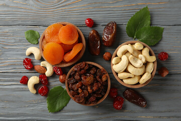 Fototapeta premium Bowls with dried fruits and nuts on gray wooden background