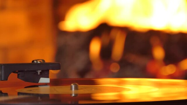 vinyl record player with a record on the background of the fireplace