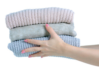 Stack folded warm sweaters in hand on white background isolation