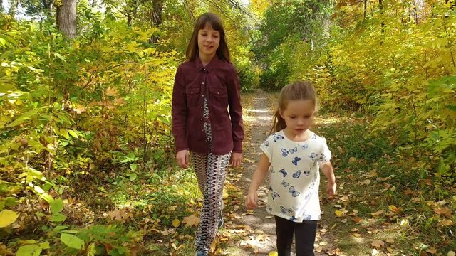 two sisters walk in the autumn Park, family relations