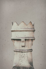 Ancient stone weathered chess tower in front of a concrete wall