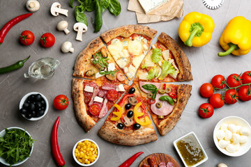 Flat lay composition with slices of different delicious pizzas on grey table