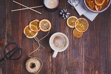 Dry oranges, coffee and candle on wooden table