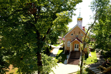 Fototapeta na wymiar The building of the Russian church among green trees.