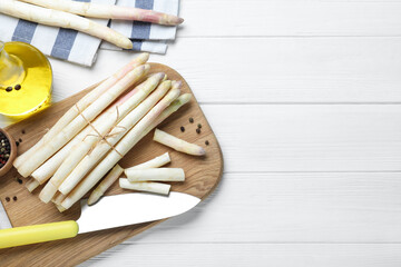 Fresh white asparagus on wooden table, flat lay. Space for text
