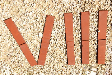 The Roman numeral eight is lined with red brick on the gravel.