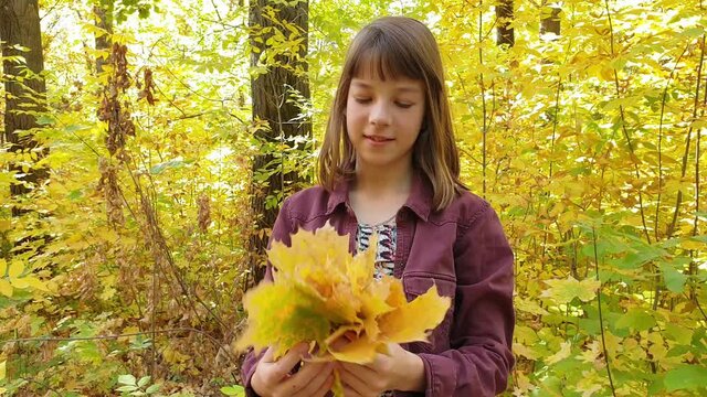 teenage girl in the autumn Park with leaves in her hands