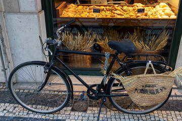 Fototapeta na wymiar bicycle in the street of Lisbon, Portugal near the window on bakery 