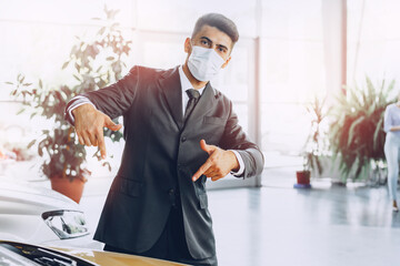 Man car dealer wearing protective medical mask on his working place