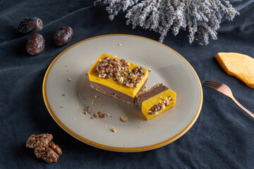 Homemade pumpkin pie with chocolate, and nuts. Sprinkled with walnuts. Laid on a plate, cut off a piece.