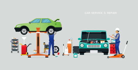 Mechanic inspecting the engine in the garage with a gray backdrop.
