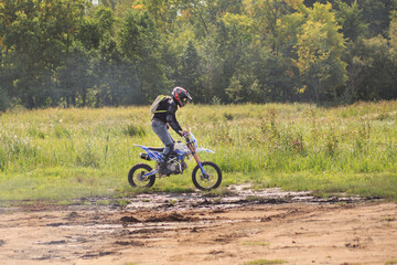 Man riding on pitbike on dirty country road