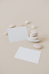 Blank paper sheet cards with mockup copy space and stones stack on beige background. Minimal business brand template.