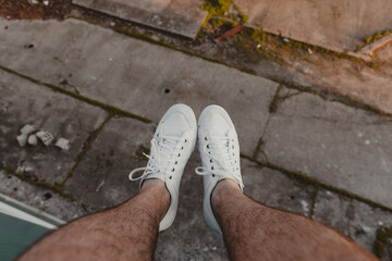 Hiker's legs hanging over the edge of a high building