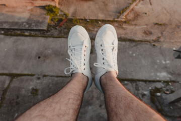 Hiker's legs hanging over the edge of a high building