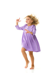 A beautiful little girl stands in the wind, her hair and clothes are developing greatly. The concept of style and fashion.