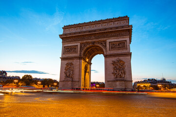 Fototapeta premium The night view of triumphal arch and traffic in Paris, France.