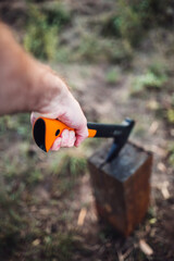 Male hand with an ax strikes a wooden log - chopping wood
