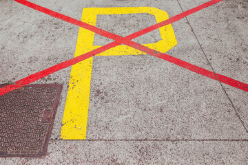 The yellow letter P on the asphalt is crossed out with red lines - parking is prohibited and no cars are parked