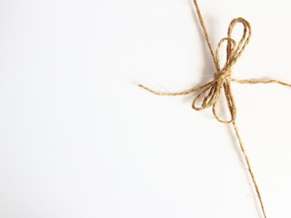 Handmade bow made of natural jute rope at the right corner - decoration for wrapping gifts