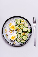 Easy vegetarian salad with cucumber, onion and eggs with vinaigrette sauce. Healthy nutrition. Selective focus