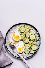 Easy vegetarian salad with cucumber, onion and eggs with vinaigrette sauce. Healthy nutrition. Selective focus