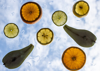 fruit slices on glass with sky background