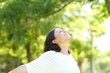 Middle aged woman breaths fresh air in a park
